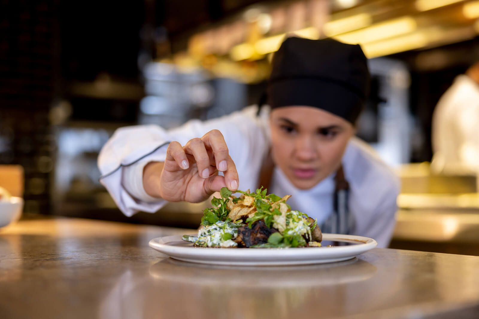 Chef adding the finishing touch to a plated dish