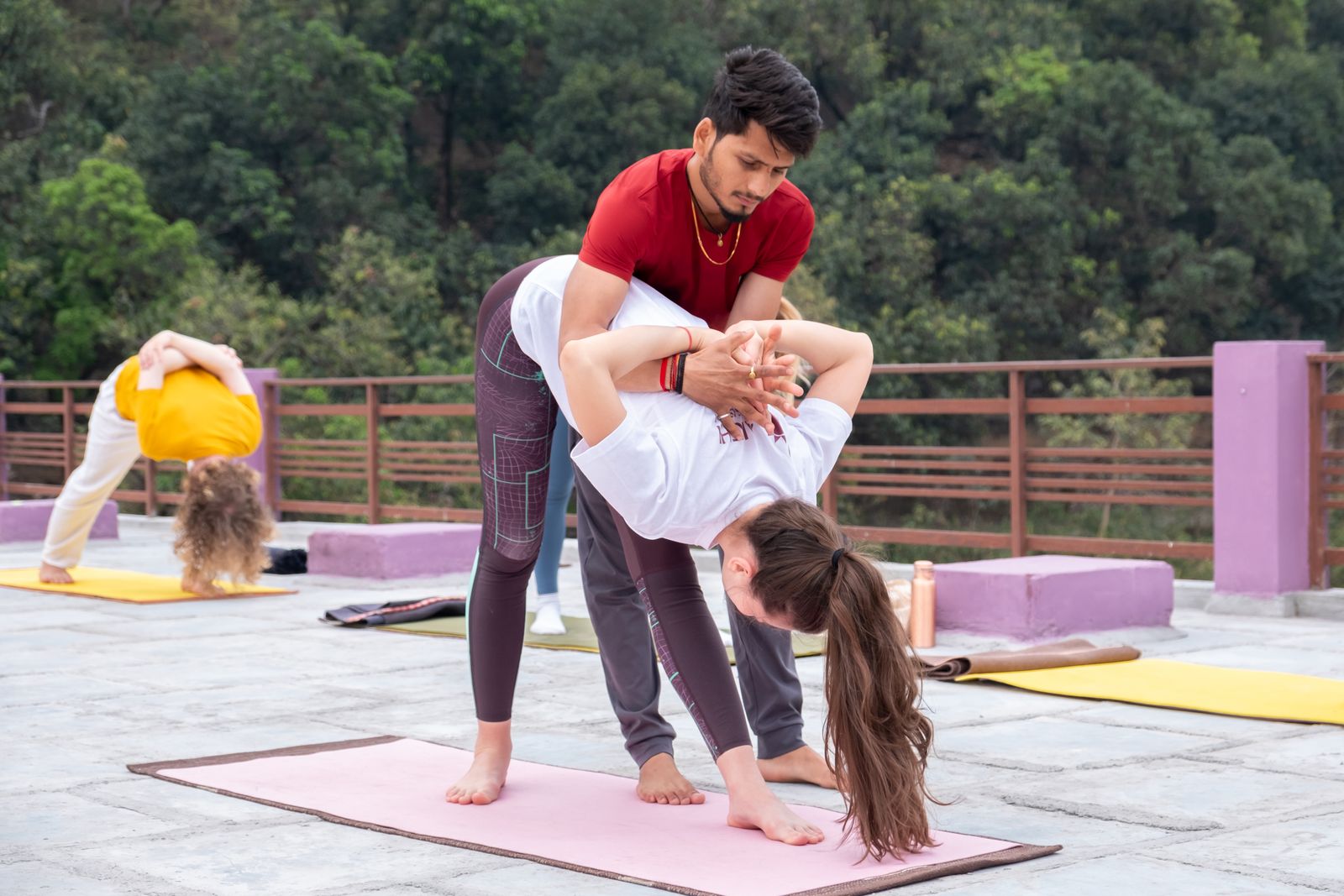 Yoga instructor guiding a guest through a pose